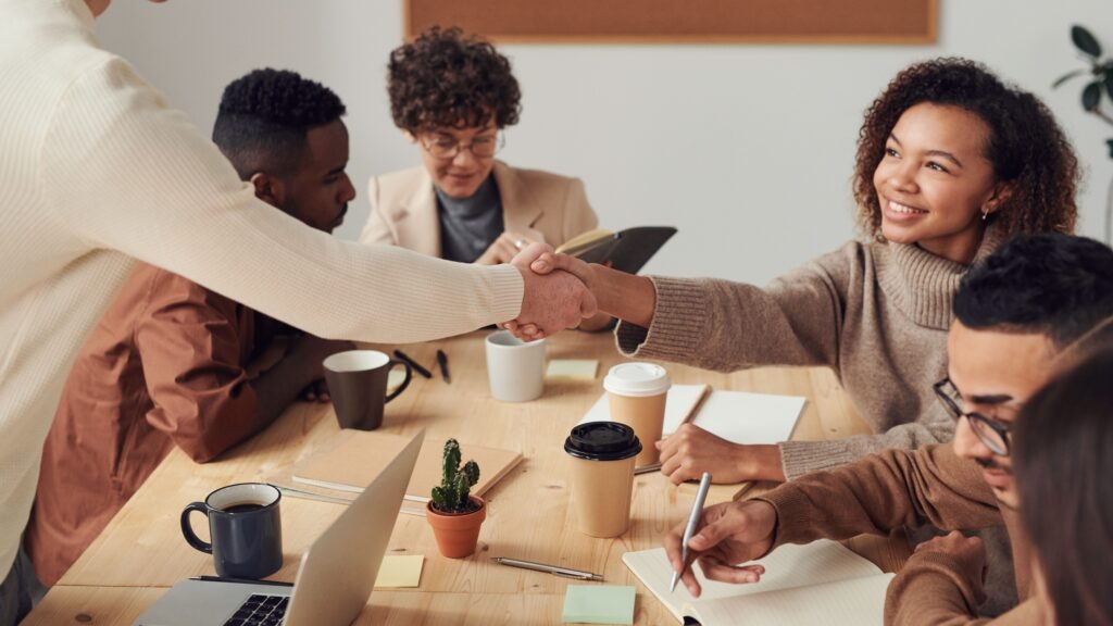 Colleagues shaking hands and welcoming a new hire, representing how to automate employee onboarding with AI