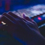 Close-up of hands typing on a laptop keyboard, representing keyboard shortcuts and browser tricks for AI tool workflows