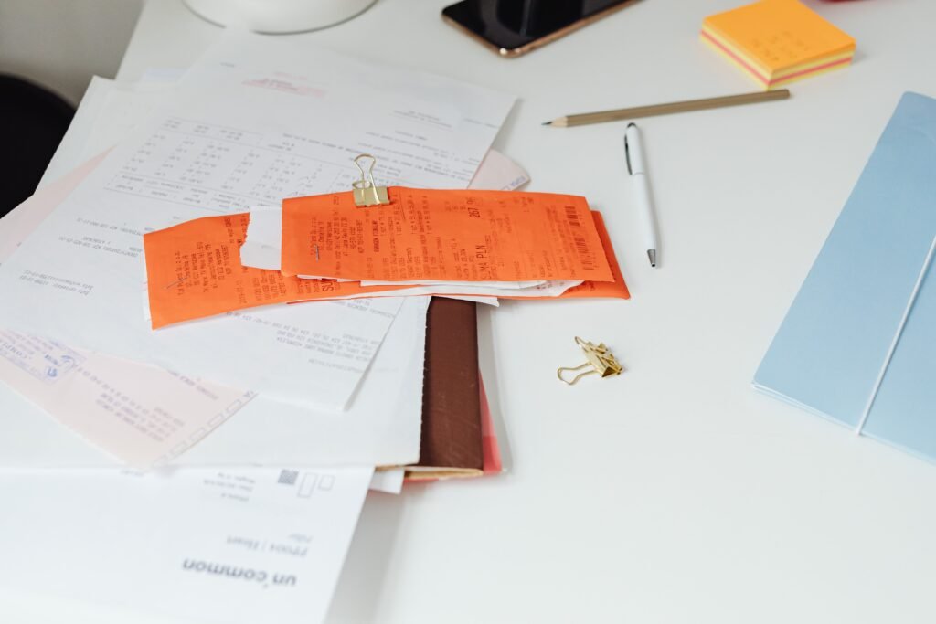 Person reviewing receipts and documents at a desk, representing how to automate expense tracking with AI